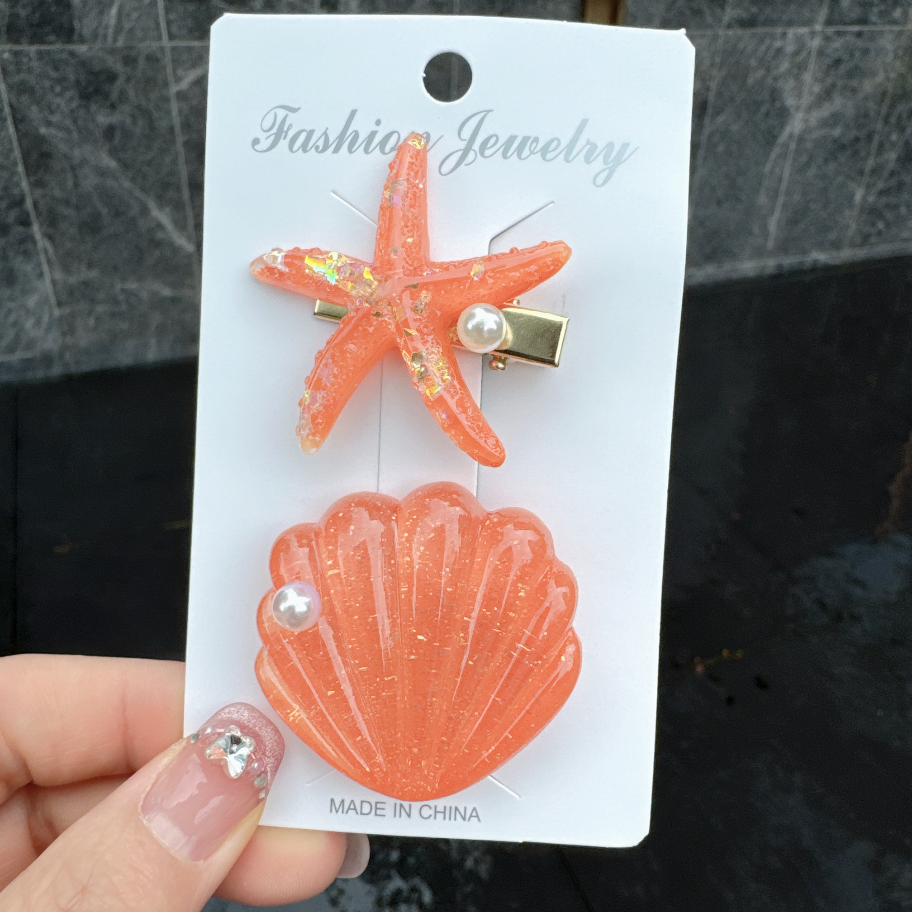 Styled flat lay of multiple ocean-themed hair clips in neutral tones