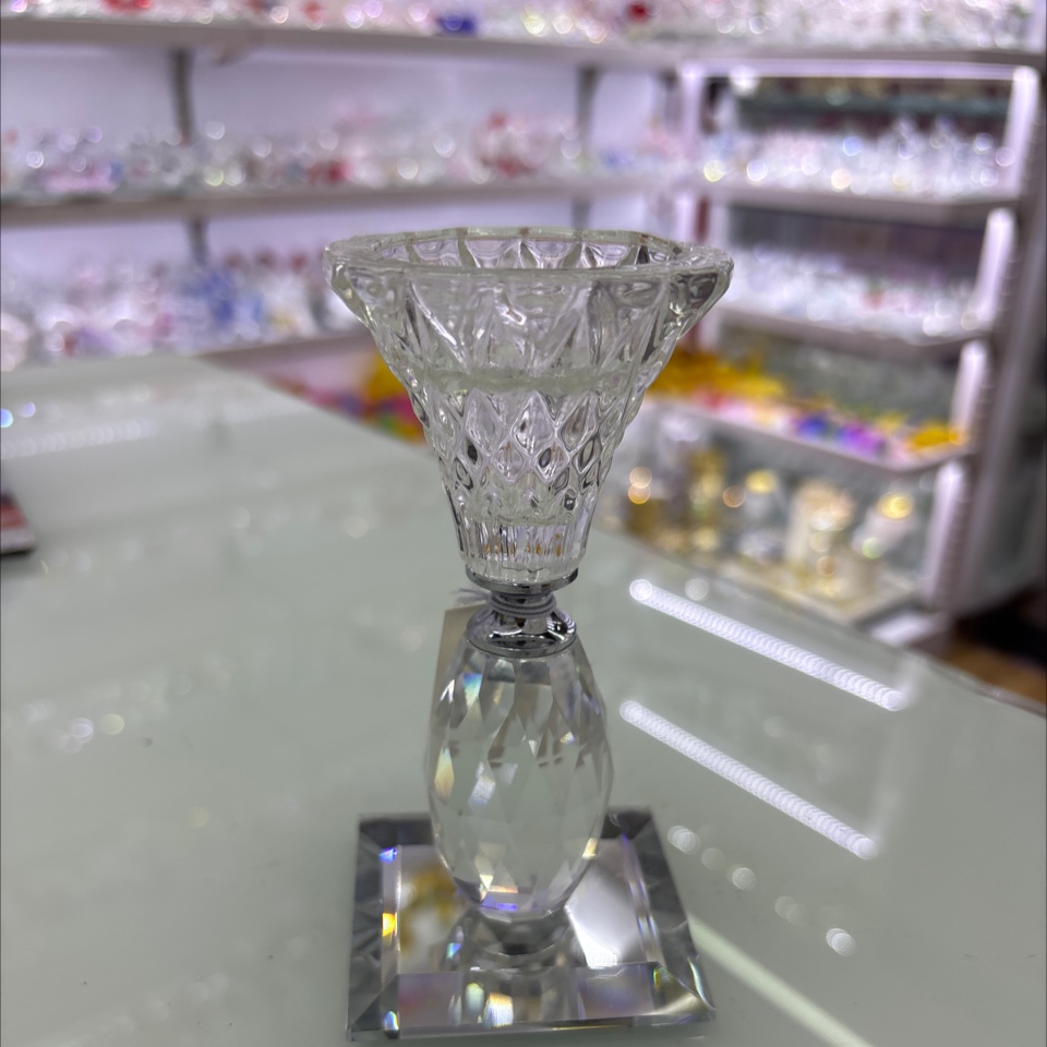 这是一个水晶烛台摆件，属于水晶工艺品。它采用透明水晶材质，通过精细的切割工艺呈现出丰富的棱面，光线照射下璀璨夺目。此类烛
