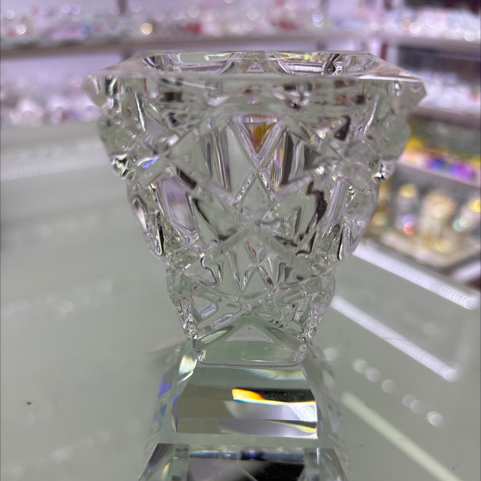 这是一个水晶烛台摆件，属于水晶工艺品。它采用透明水晶材质，通过精细的切割工艺呈现出丰富的棱面，光线照射下璀璨夺目