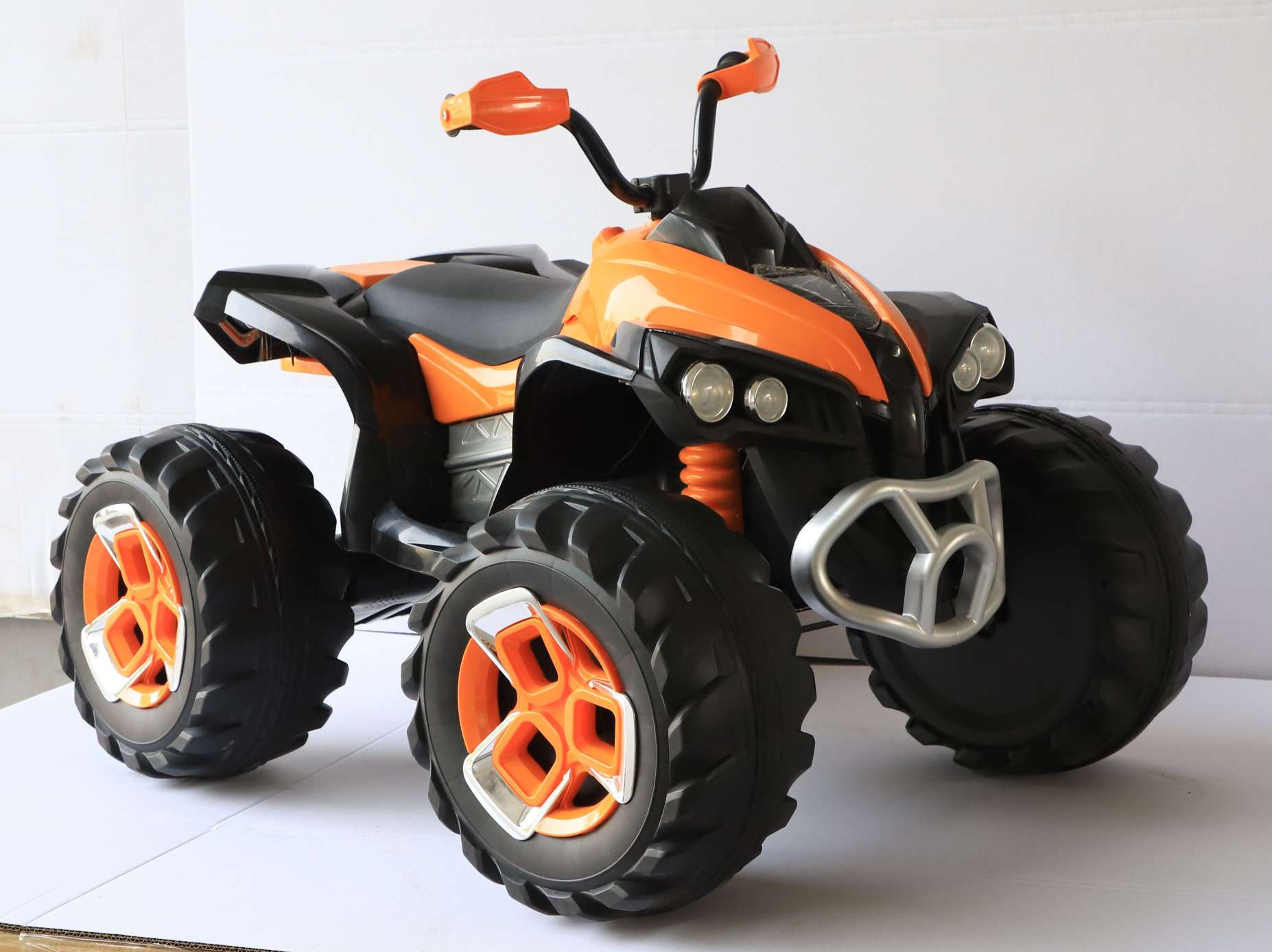 The main body of the orange children's electric four-wheel motorcycle is open to traffic