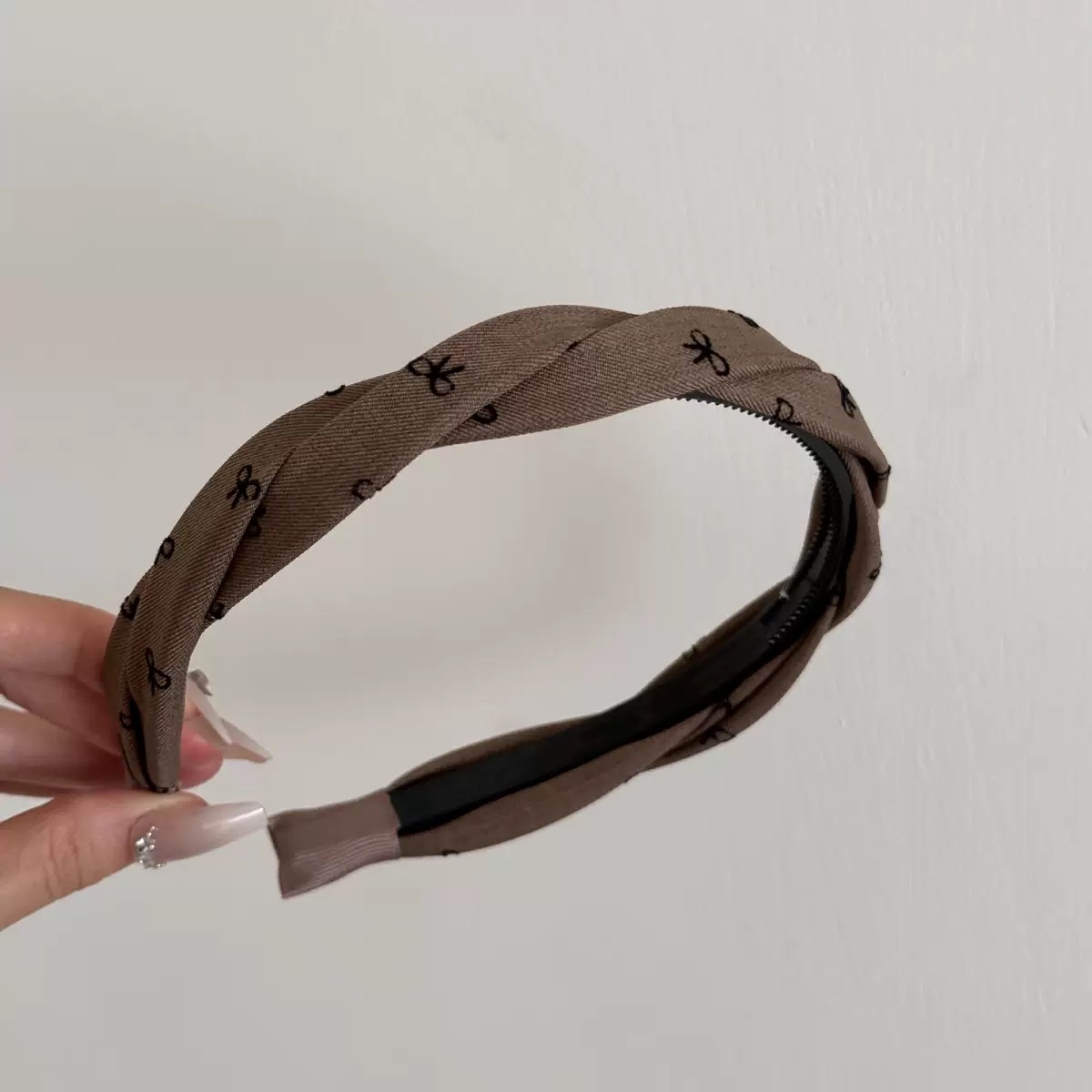 The Korean-style Xiaoxiang Wind Wave double twisted twisted toothed hairband is versatile. It features a high top, wide edge, pressure hairband, headband, and a butterfly-shaped hairband for women Item Picture