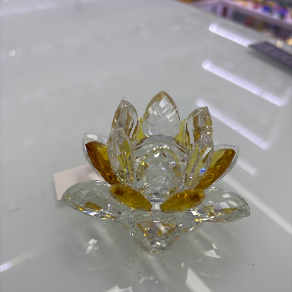 这是一件水晶莲花摆件，通常由K9水晶或高透玻璃切割打磨而成，图中这款为透明+金色渐变的款式。