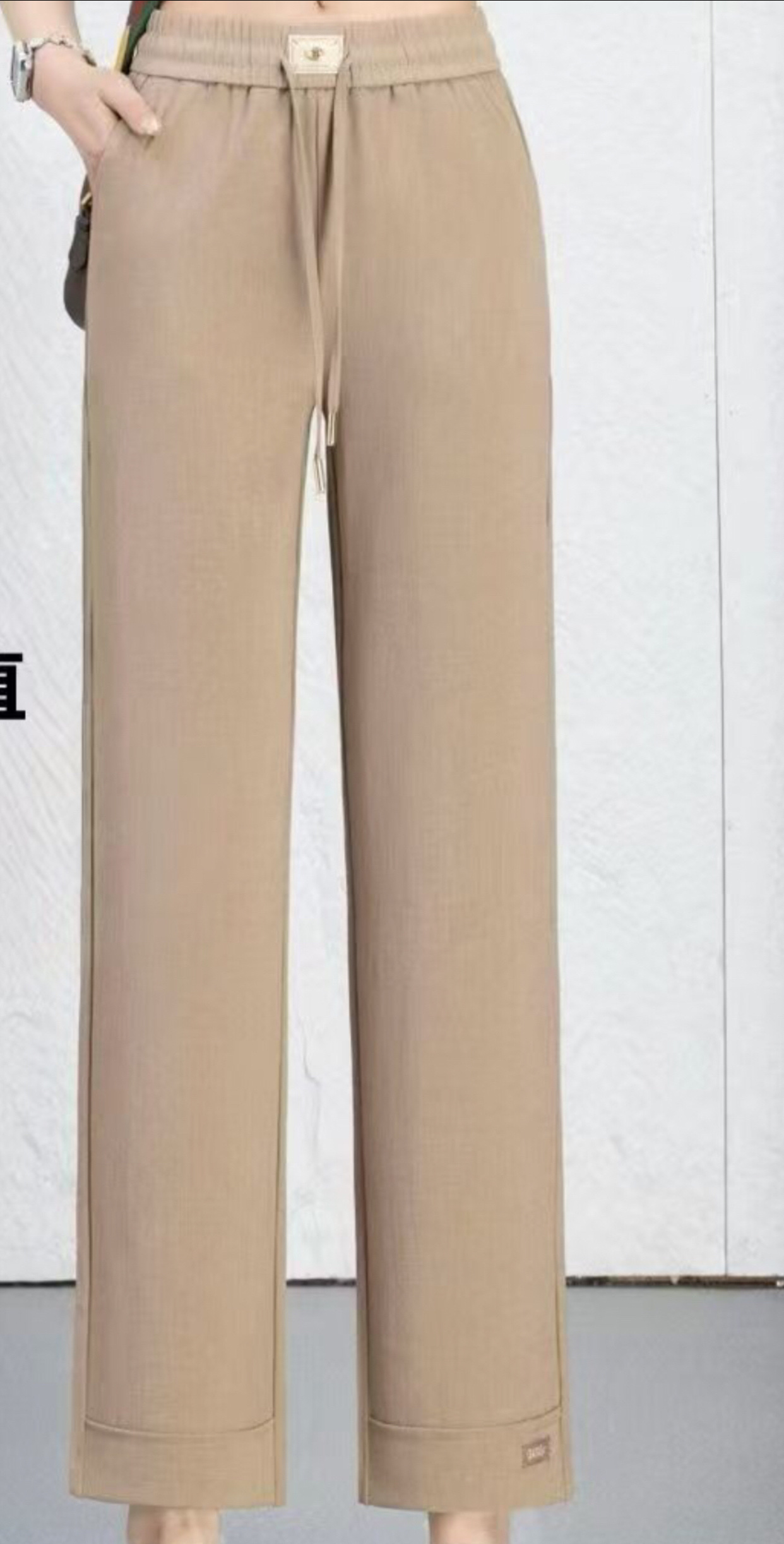 The trendy women's trousers for Spring and Autumn 2026 are the linen straight-leg pants with an elastic waist and khaki color details Picture