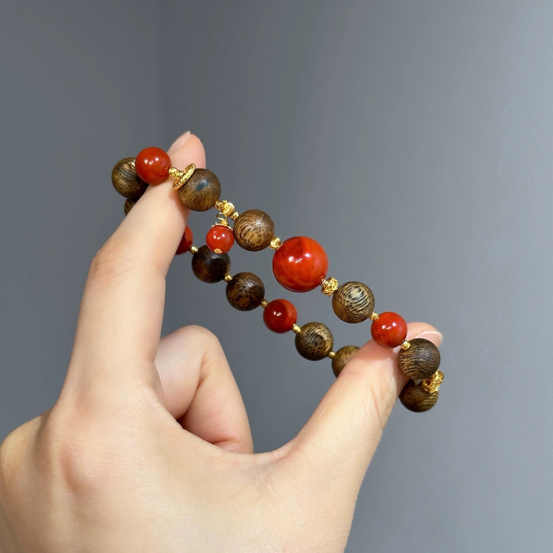 This is an old material agarwood bracelet made of rare agarwood and Sichuan material Nanhong agate. It is an ancient method gold bracelet for men and women details Picture