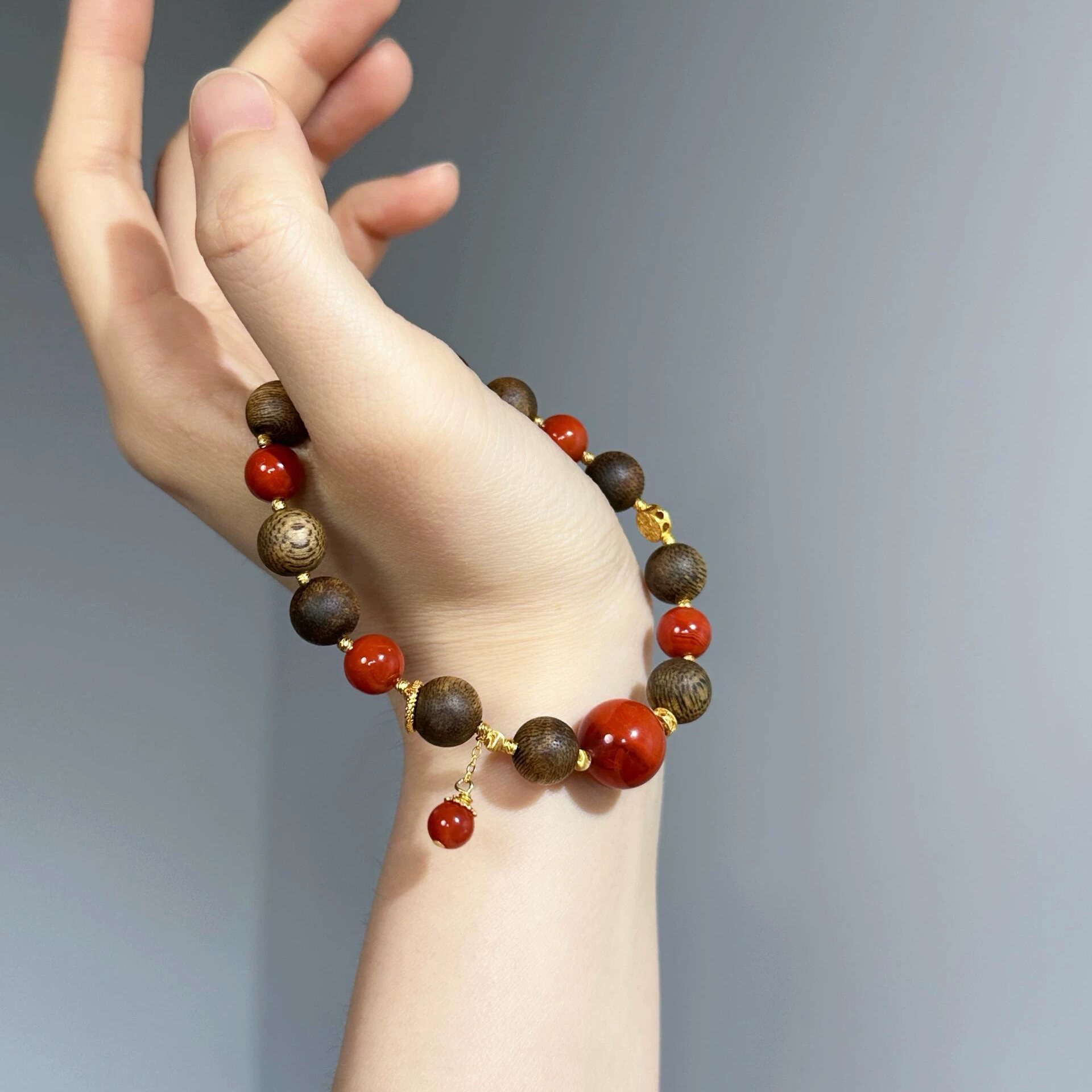 This is an old material agarwood bracelet made of rare agarwood and Sichuan material Nanhong agate. It is an ancient method gold bracelet for men and women Application Scenario