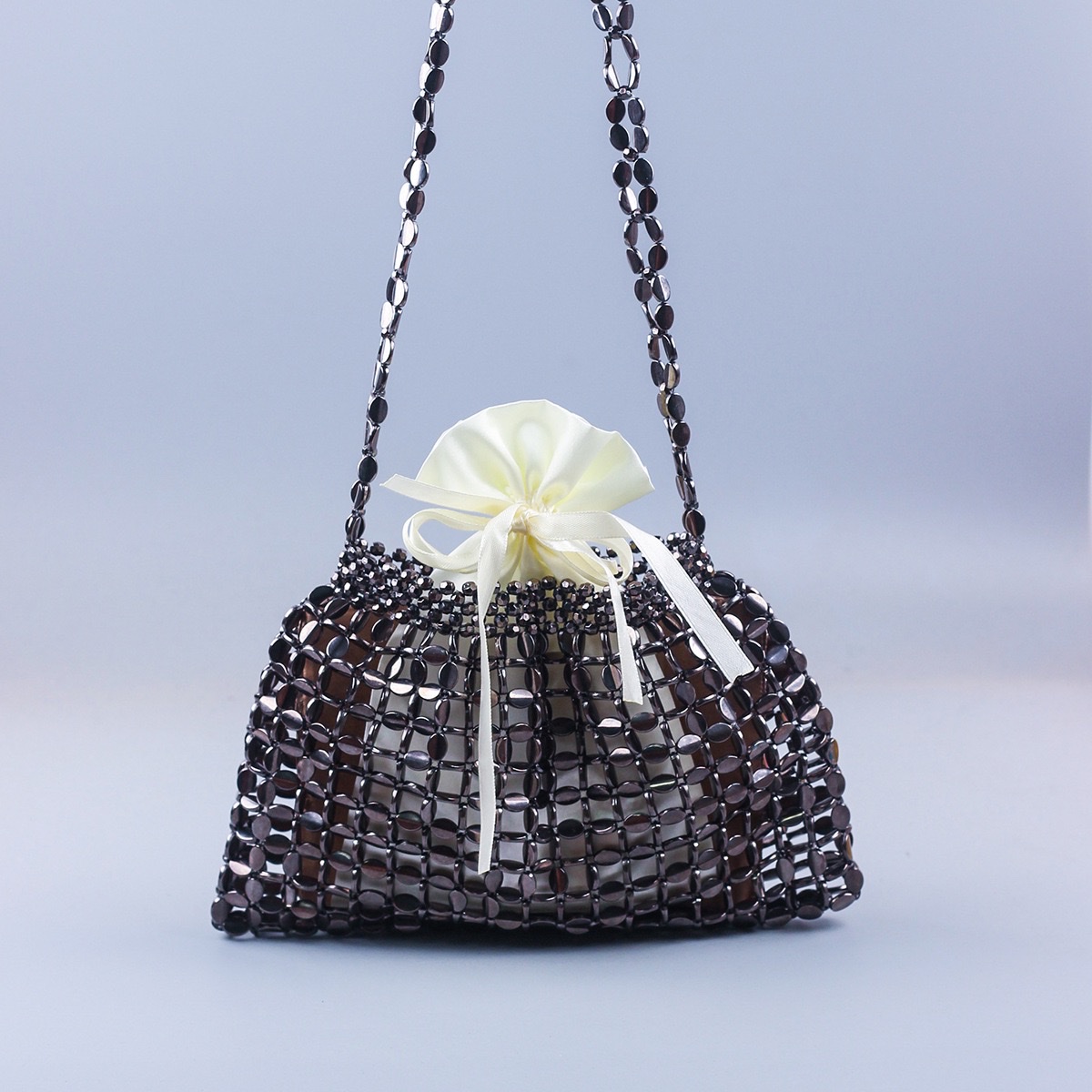 This is a trendy and fashionable single-shoulder handbag featuring handcrafted silver and gold flat beaded and woven large dumplings Item Picture