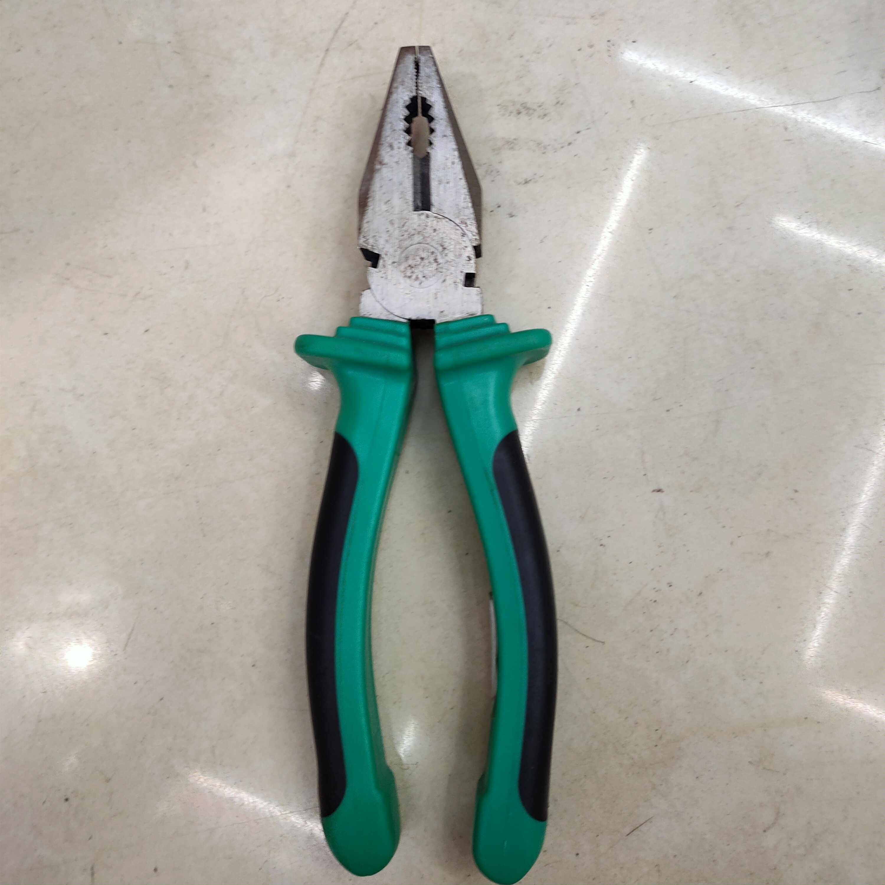 Green-handled wire pliers are used to cut hand-made pliers for construction