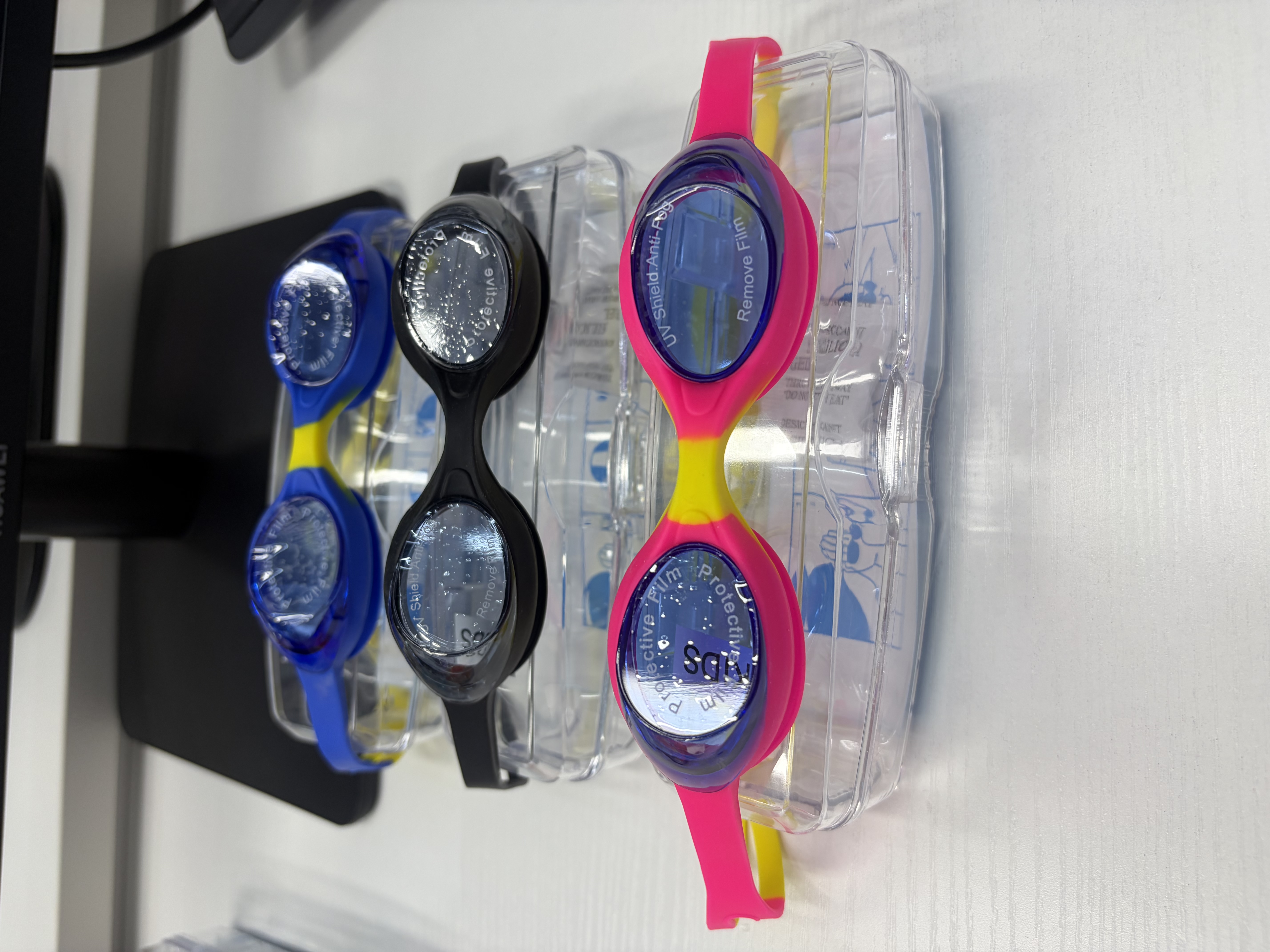 Three pairs of colored swimming goggles in blue, yellow, black, pink and yellow, with protective film and transparent storage box detail image 1