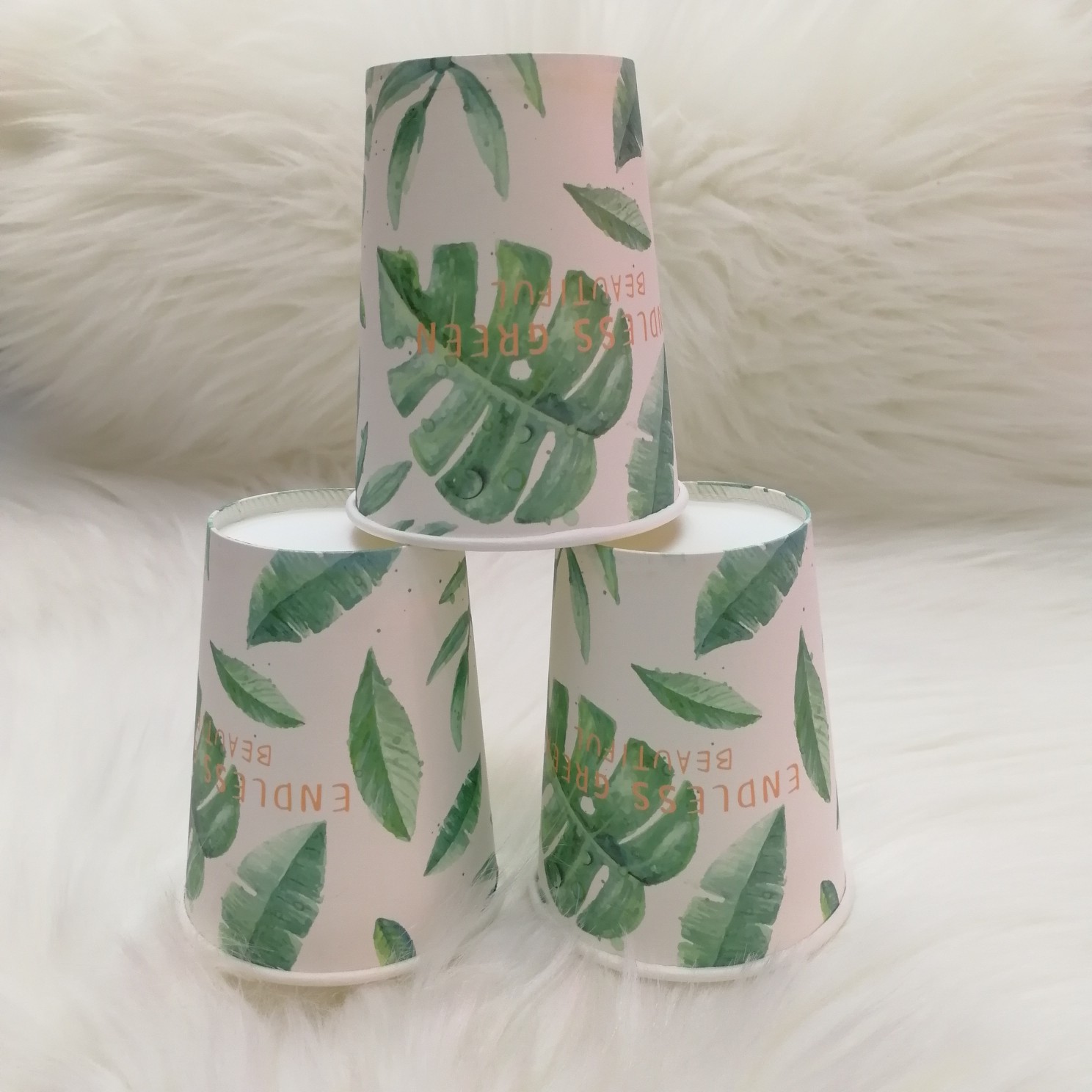 Stacked green leaf paper cups in natural outdoor setting