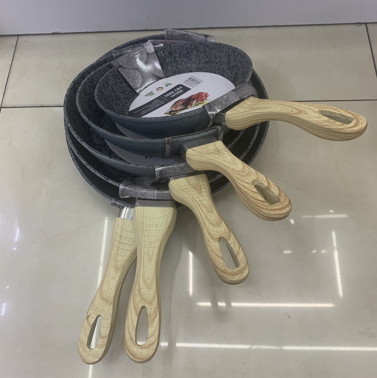 The wood-grain handle extrudes the granite of the frying pan