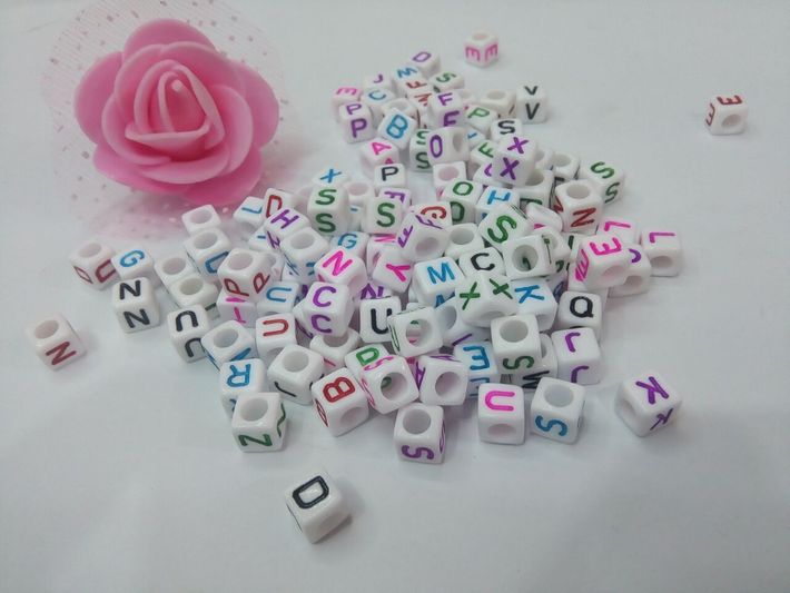 Diy cube letters with beads on a white background