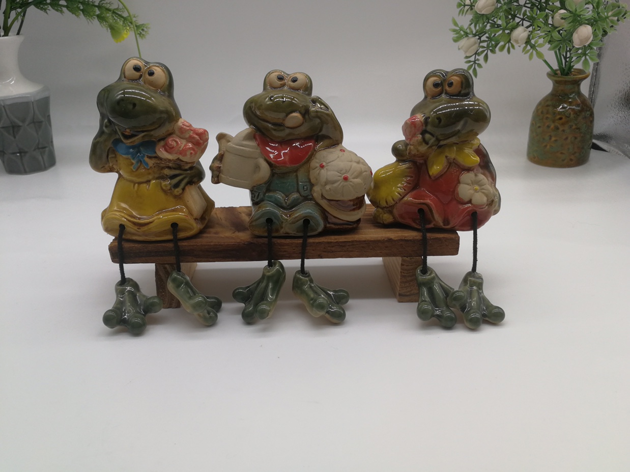 A family of three hanging feet ceramic cartoon frog, including stool style