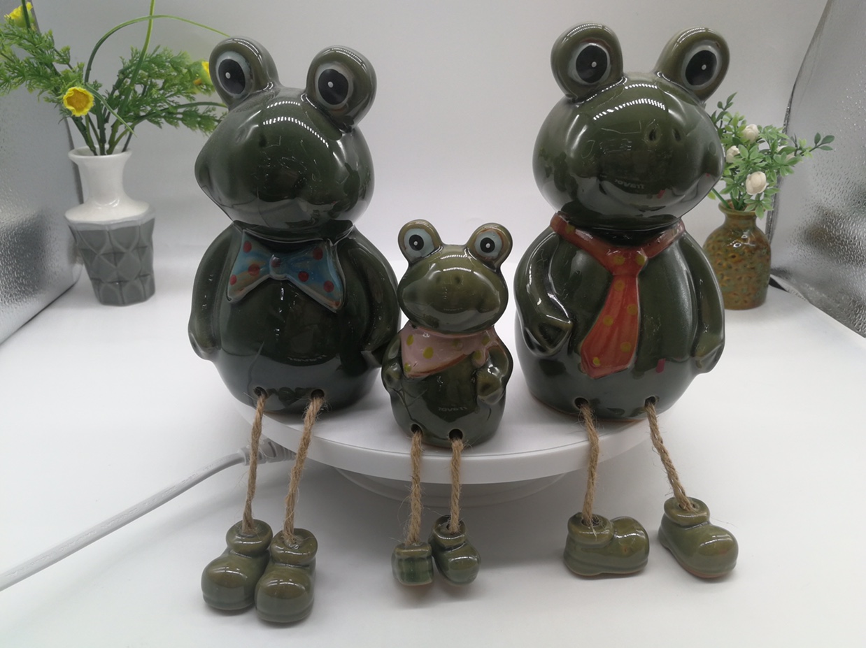 A family of three feet hanging ceramic cartoon frogs