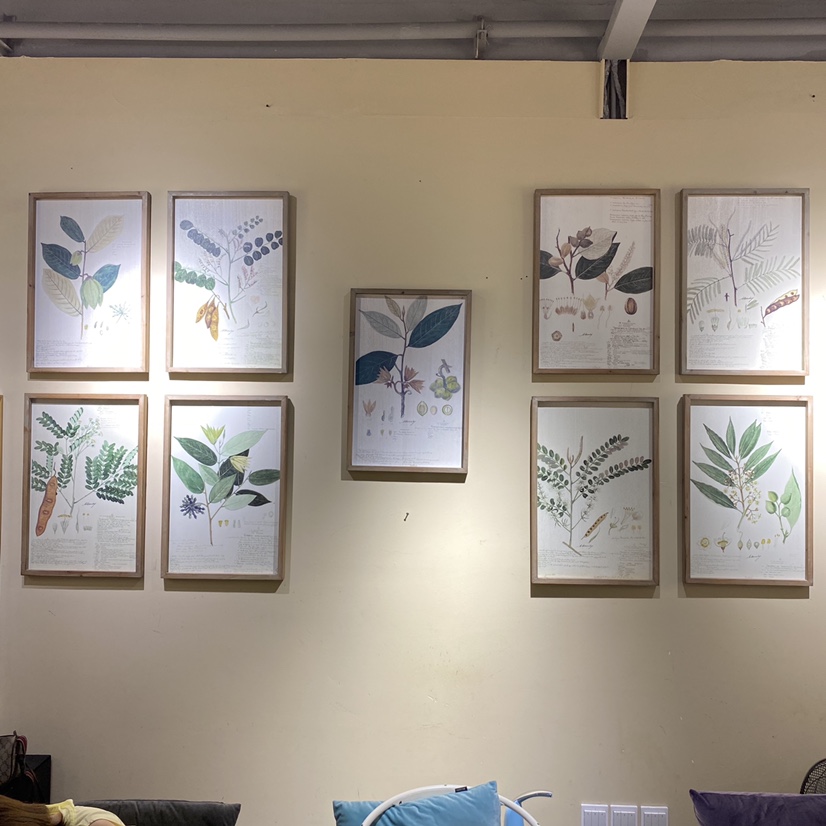 The living room wall is hung with nine paintings thumbnail