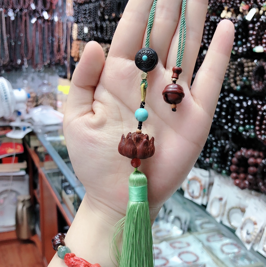 A small bag hanging with a purple sandalwood carved lotus flower