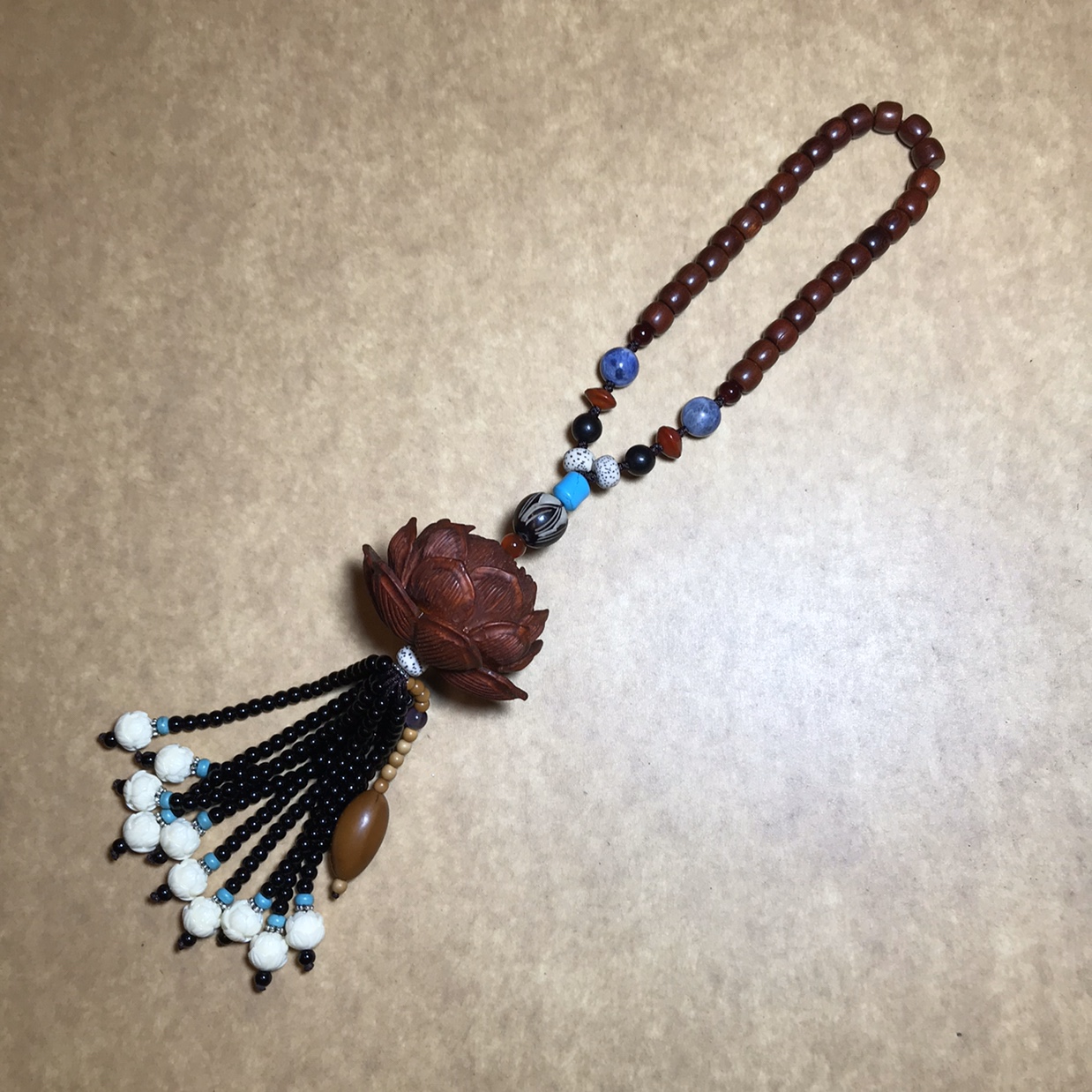 A five-layer lotus pendant made of rosewood with black agate beads
