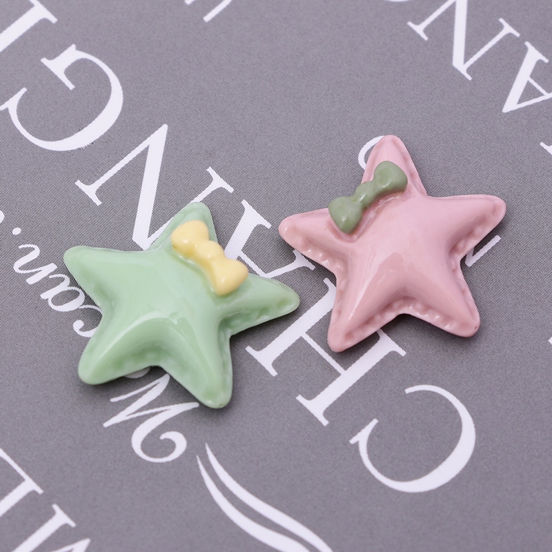 Close-up of resin star earrings and necklace on fabric