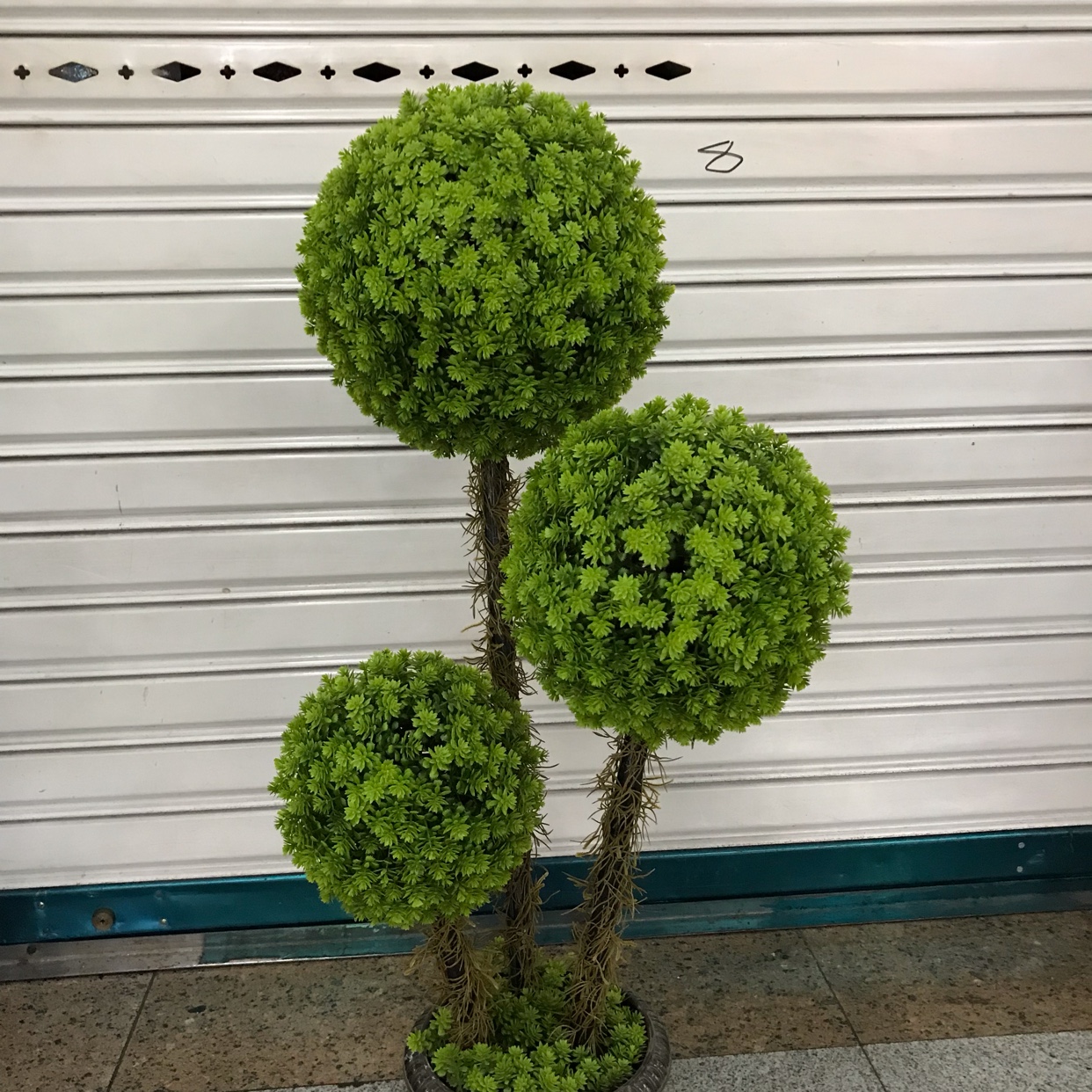 For the background decoration of the living room, the first choice for artificial plant decoration is the three-pronged bonsai