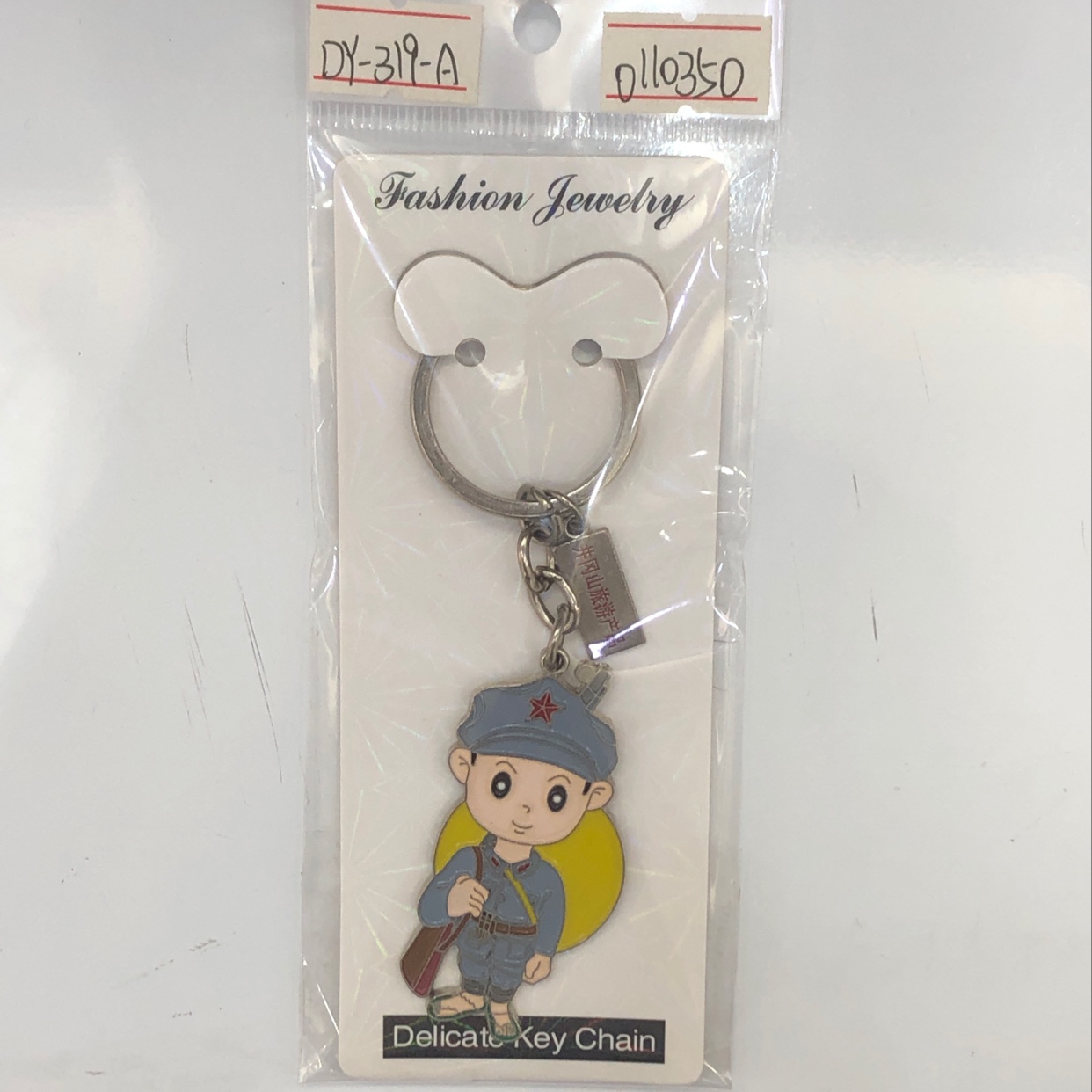 A keychain of a little Red Army boy from Jinggangshan with a dripping oil tag