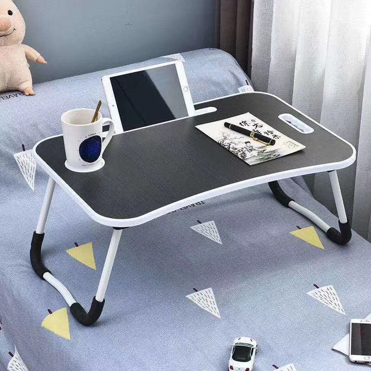 A small desk on the bed, a folding computer desk and a lazy desk