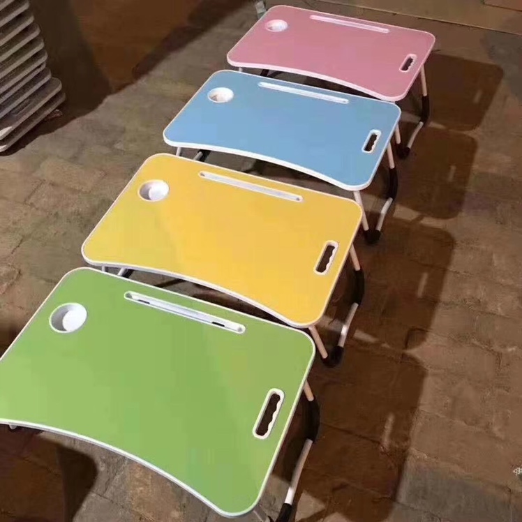 A small desk on the bed, a folding computer desk and a lazy desk undefined