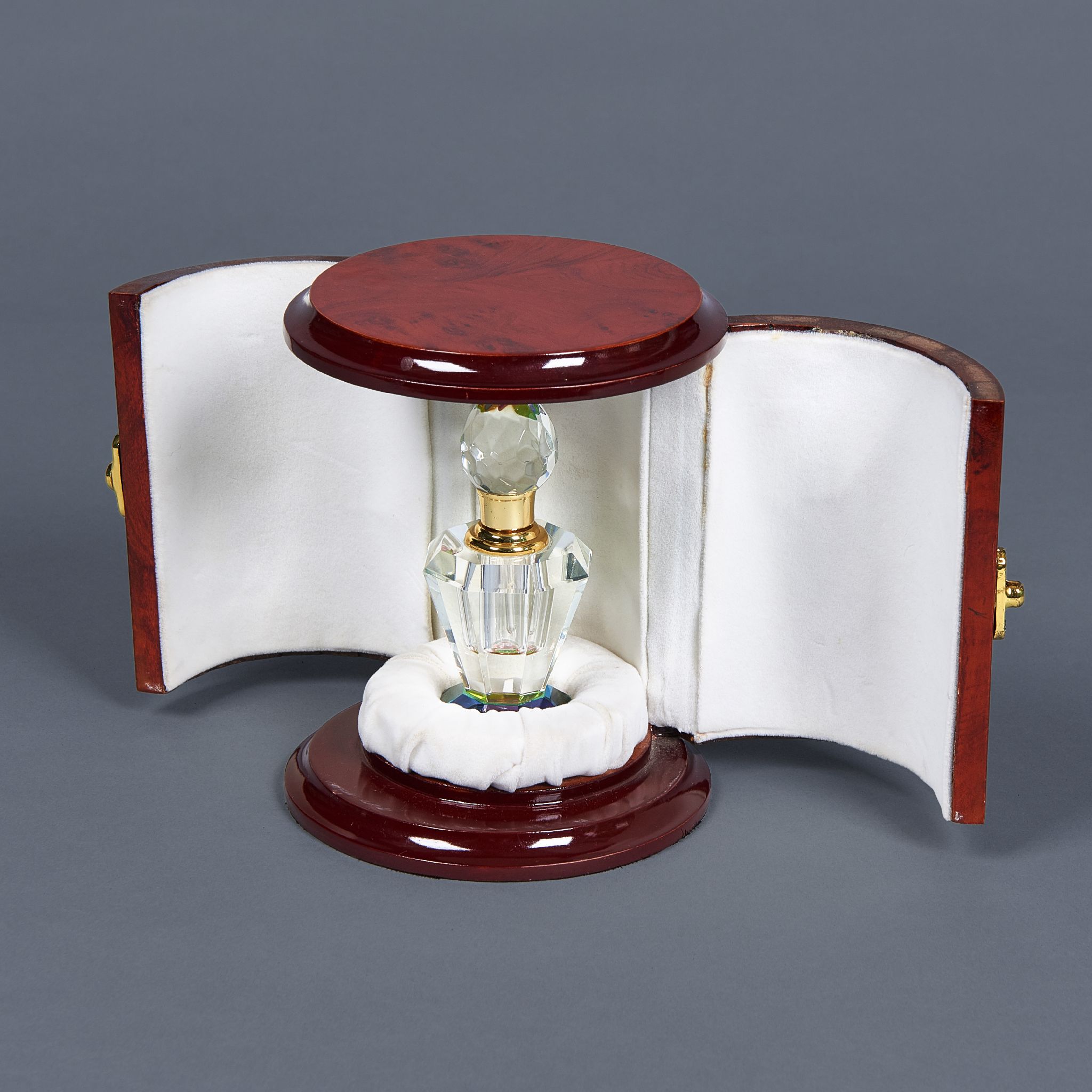 A round double-door wooden box with a crystal perfume bottle set
