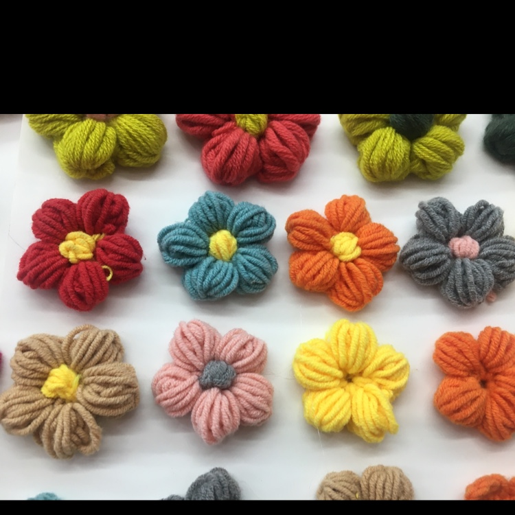 Handmade yarn flowers arranged in a vintage teacup on a lace doily