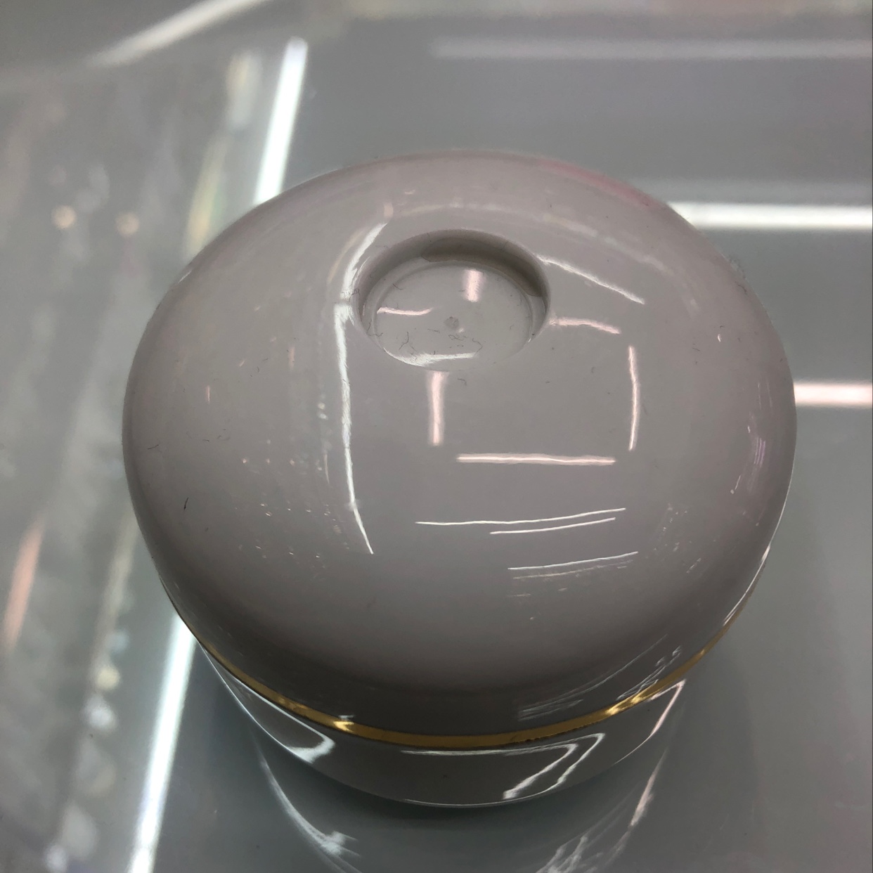 White gold-rimmed cream bottle