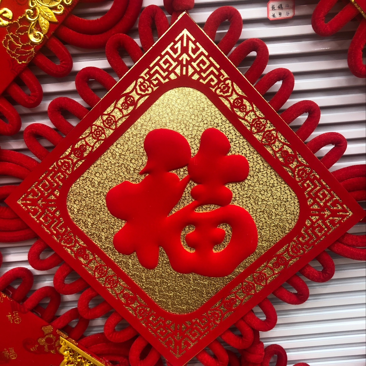 A large red lucky fish hanging on a vase with hollowed-out patterns