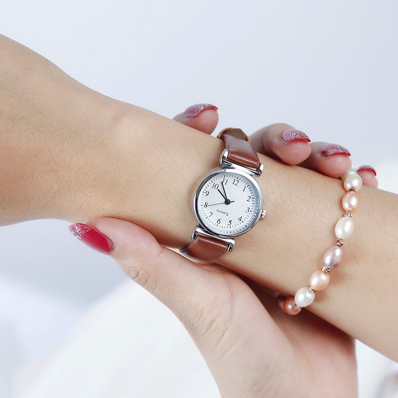 A digital watch with a thin leather strap detail image 3
