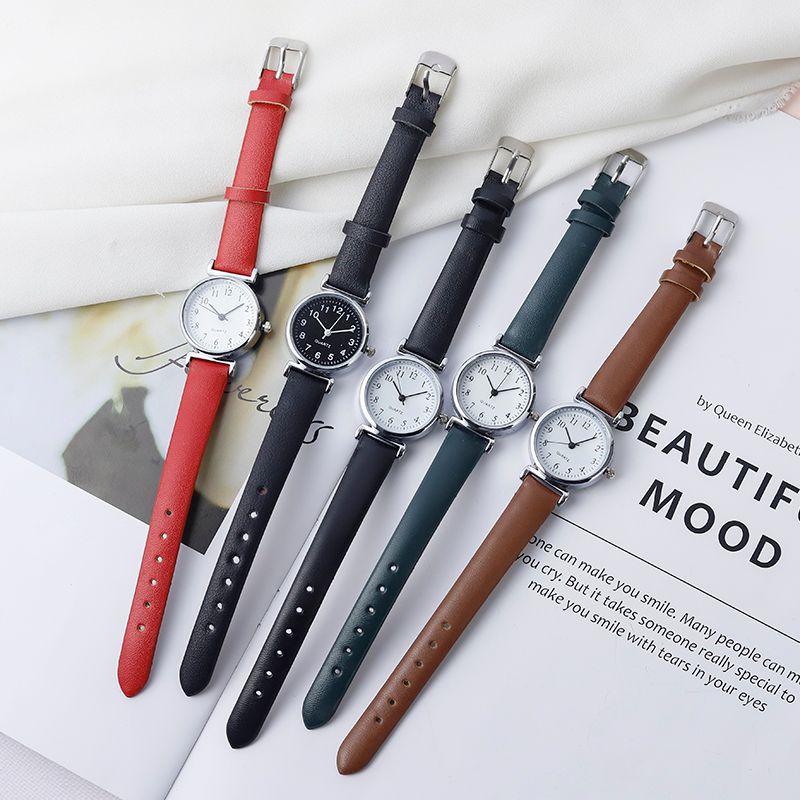 A digital watch with a thin leather strap detail image 1