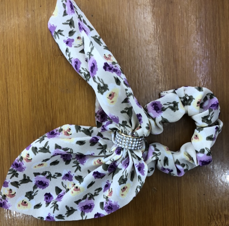 A chiffon white floral bow adorned with diamonds and a large intestine circle Hong Kong star accessory