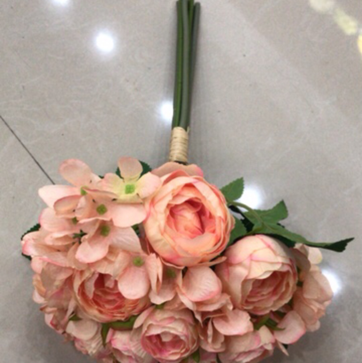 A hand-held bouquet of lotus and hydrangea