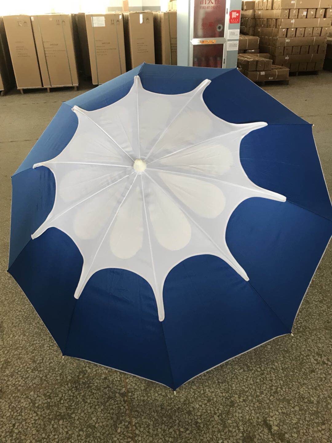 A portable folding umbrella with a blue canopy for wind and sun protection pic 3