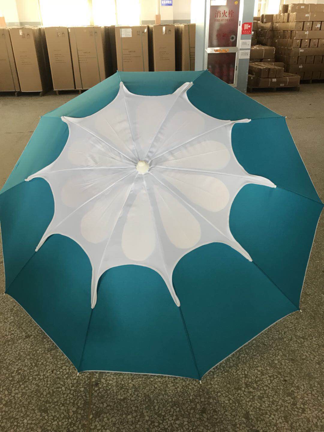 A portable folding umbrella with a blue canopy for wind and sun protection pic 1