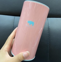 A macaron-colored tinned piggy bank, a pen and a can of rhino