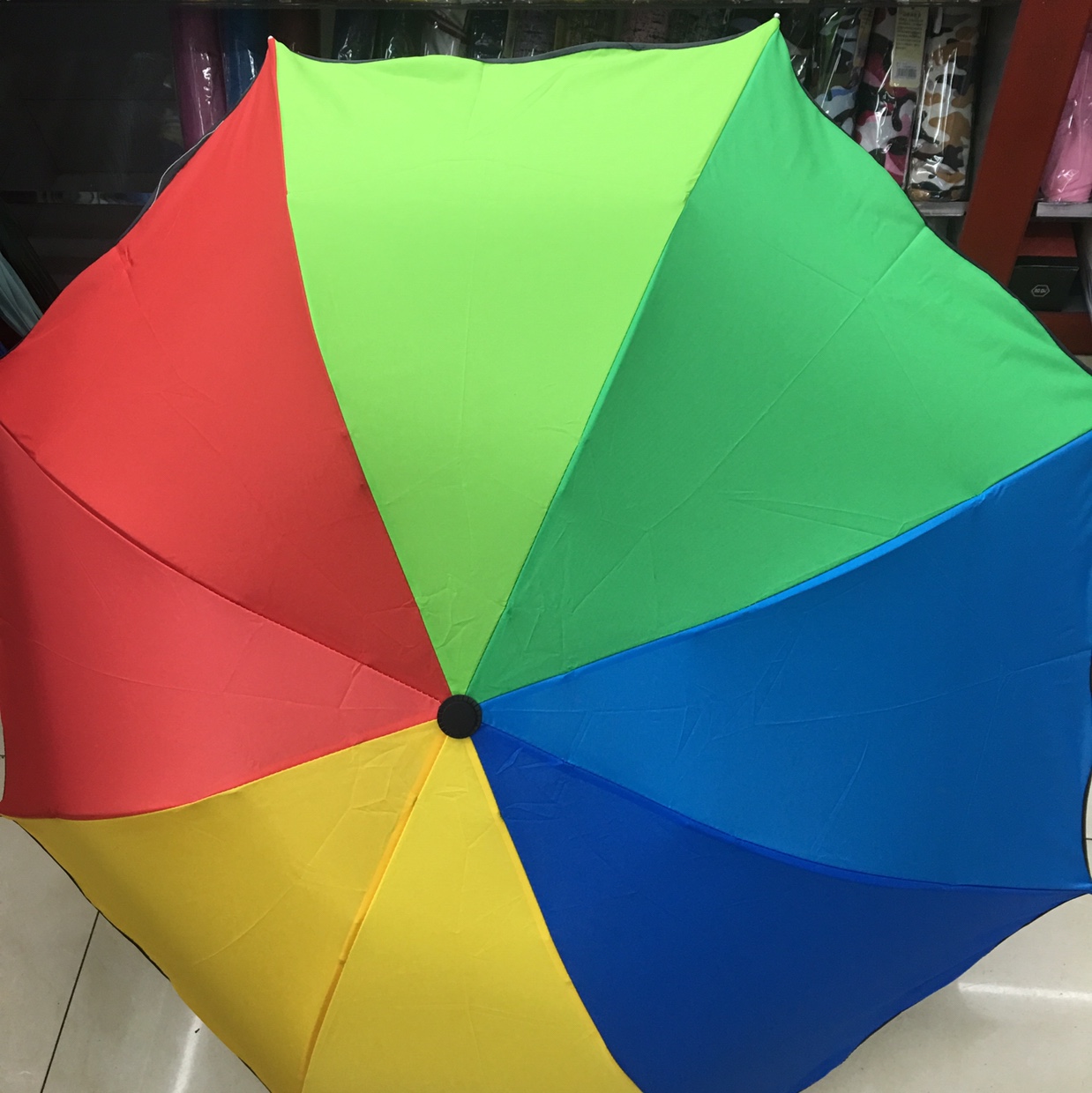 A 55-centimeter ruffled edge touches a rainbow three-fold umbrella