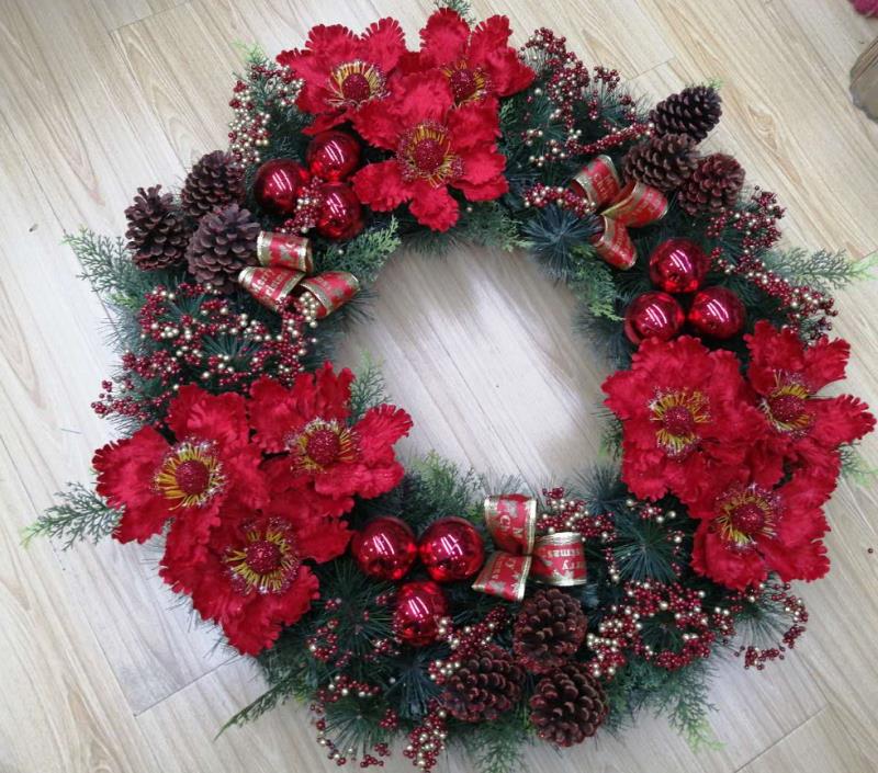 A artificial plant with a large red flower wreath, a single pink flower, white fruit and forked fruit details Picture