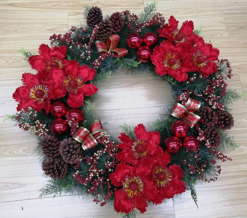 A artificial plant with a large red flower wreath, a single pink flower, white fruit and forked fruit