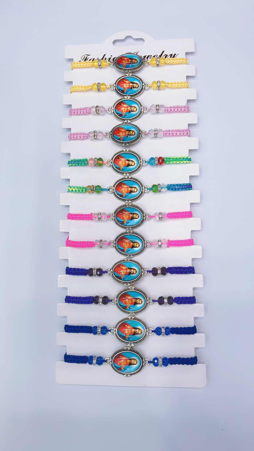 The plain knot woven bracelet features crystals on both sides, flat diamonds, an alloy in the middle and a religious pattern of glass