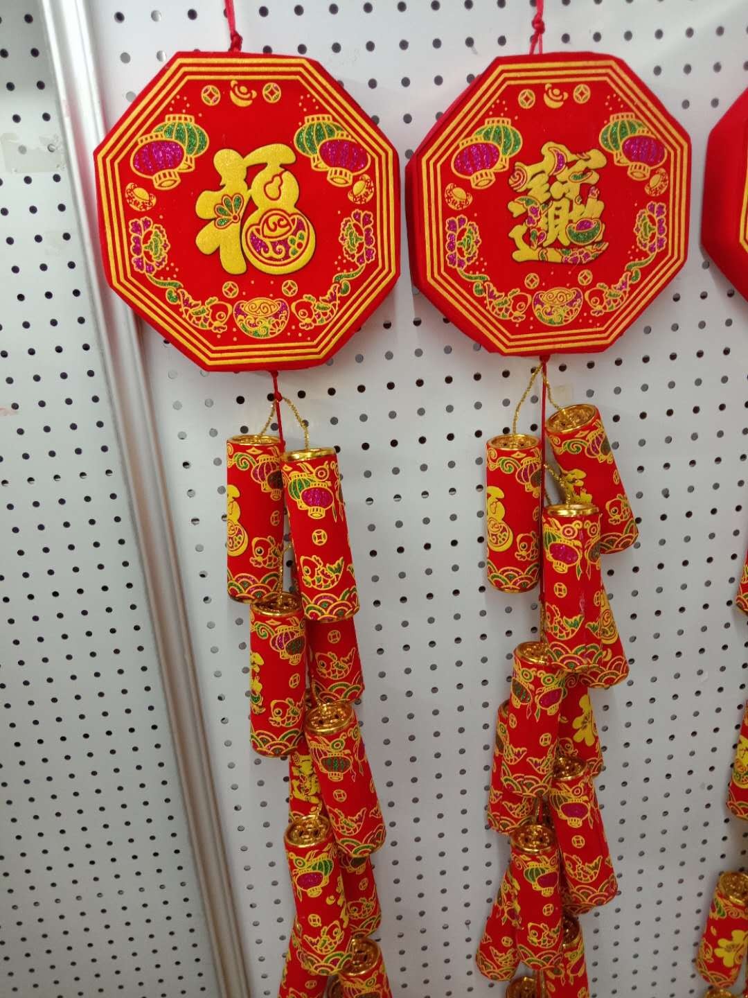 A huge string of firecrackers is hung on an octagonal stick pic 1