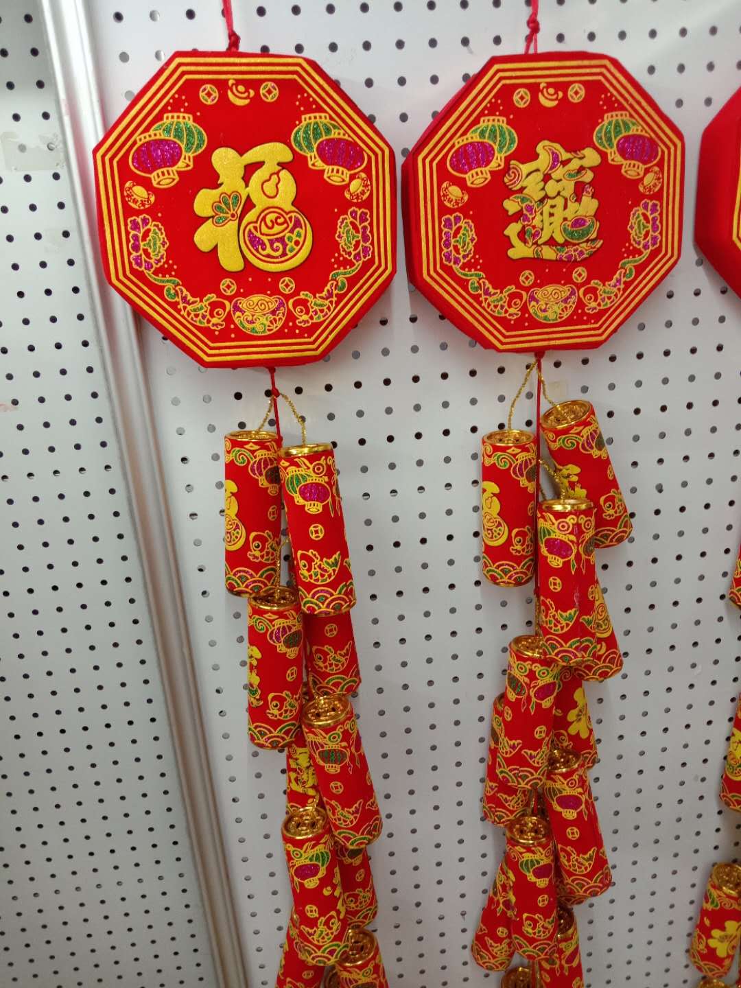 A huge string of firecrackers is hung on an octagonal stick