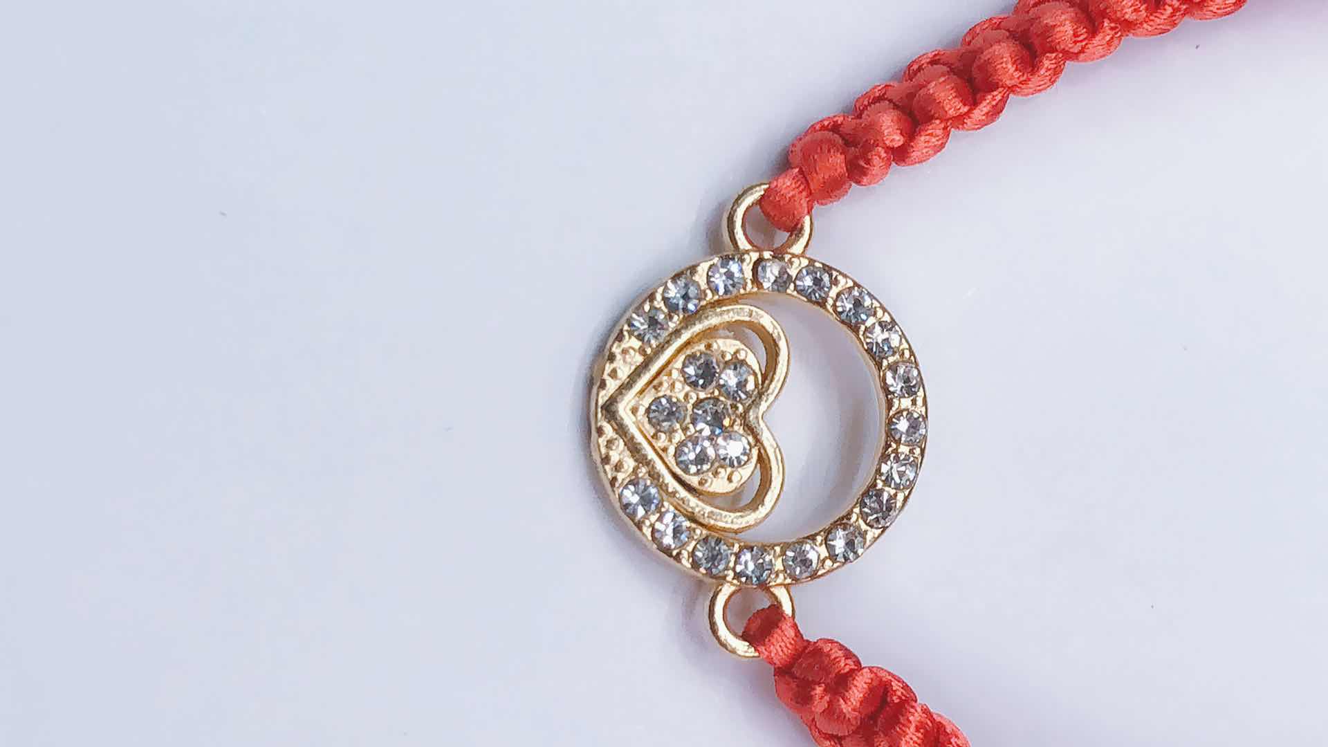 The plain knot woven bracelet is made of alloy with a circular shape and a heart in the middle Specification image