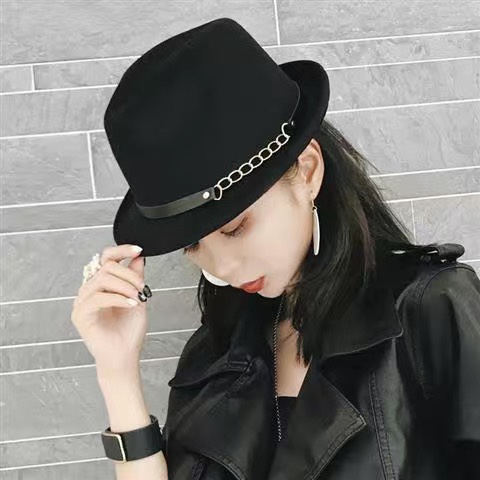 A woman wearing a woolen top hat decorated with iron chains