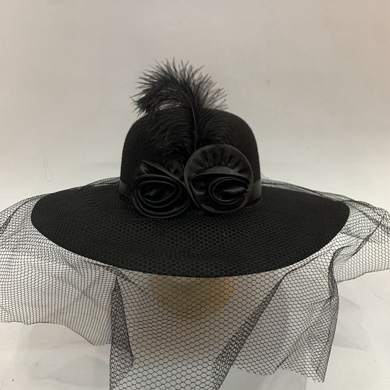 A lady's hat with feathers, two rose cloth flowers, a large brim covering the face