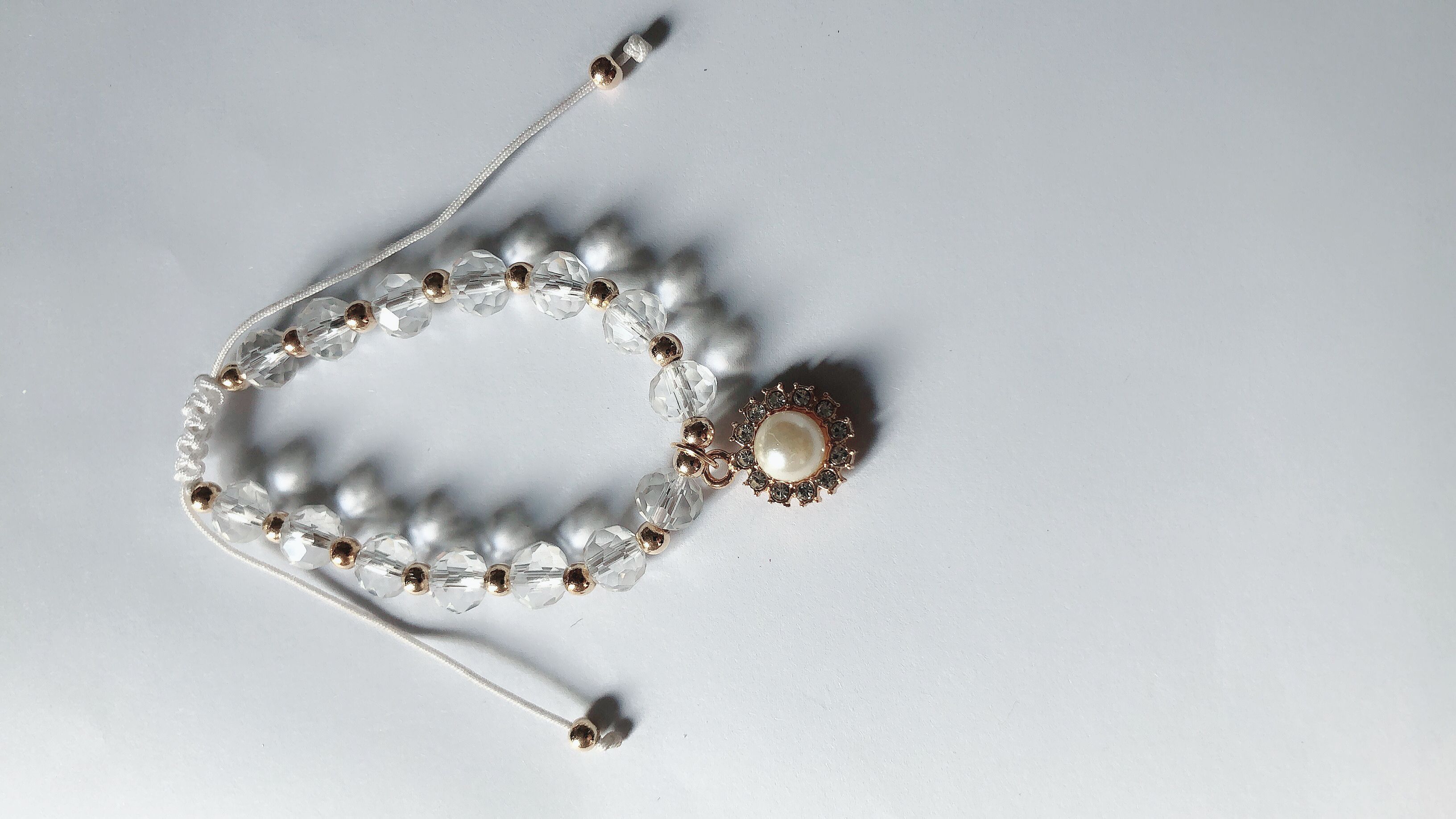 Braided bracelet with a crystal ending with a flat combination of gold dot diamonds and pearls thumbnail