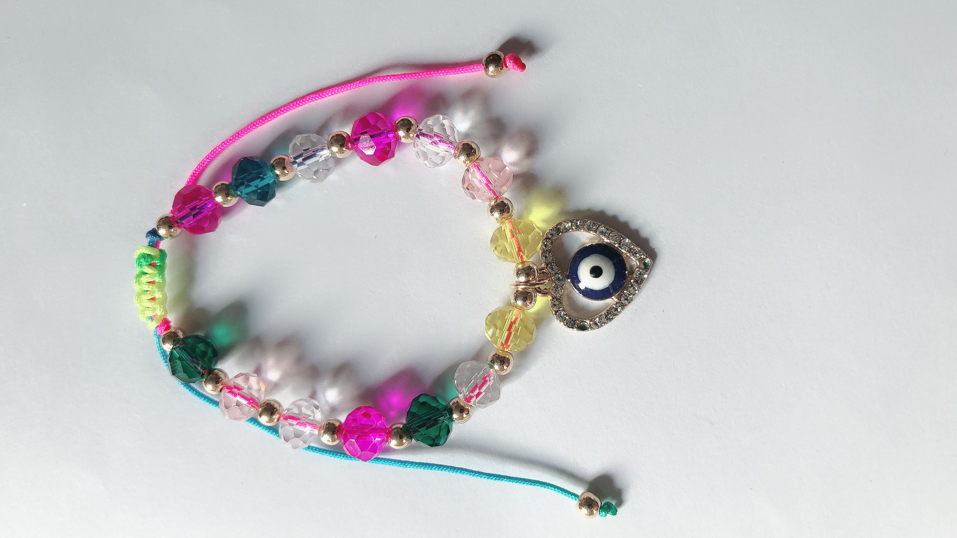 Braided bracelet with crystal ends and flat combined with gold heart and peach middle eyes thumbnail