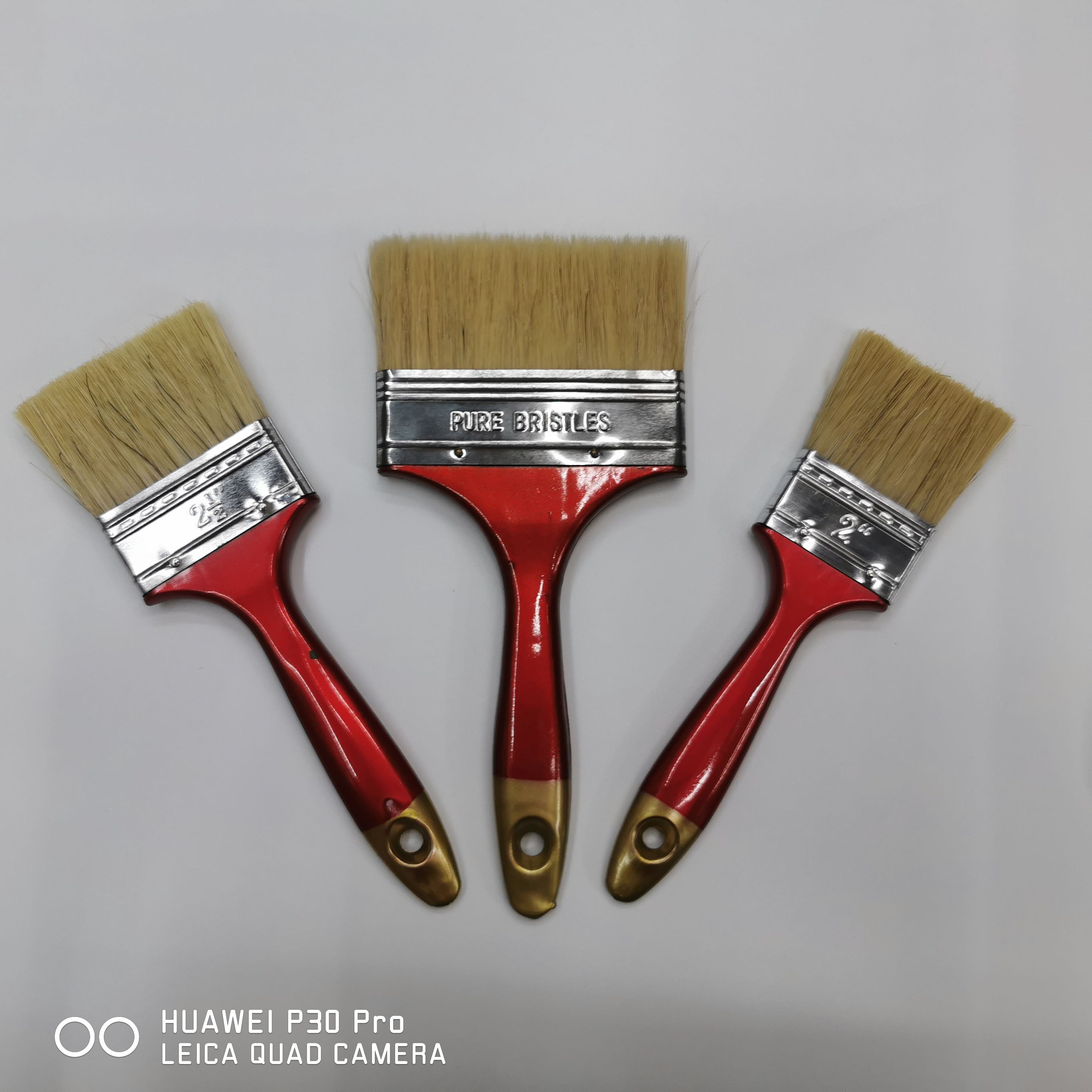 The paint brush roller brush is a high and medium-grade export product that is a bestseller in foreign trade. It is a white brush with a red plastic handle and a golden tail that leaves no trace when cleaning dust