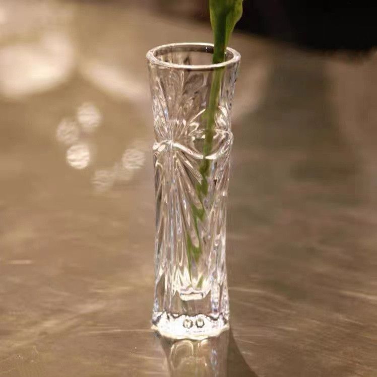 A transparent glass vase, a simple and fashionable dining table, a flower counter in a hotel room, a mini flower arrangement vase