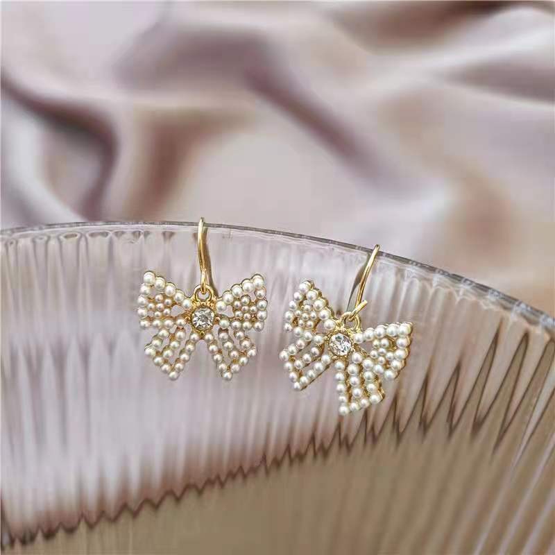 Cute bow pearl inlaid lady's cold and simple style earrings detail image 1